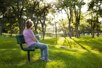 ensam kvinna på en bänk i en park