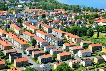 Huskvarna med flerbostadshus, vegetation och sjön Vättern.