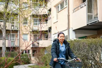Person på cykel i ett bostadsområdes innergård