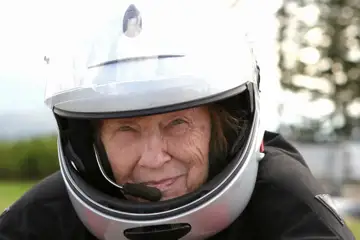 Äldre kvinna med motorcykelhjälm