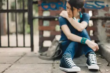 Ung tjej sitter på marken