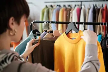 Kvinna tittar på tröja i butik