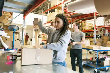 Ung kvinna som arbetar på lager