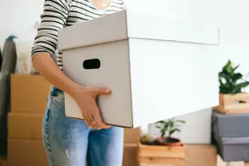 Kvinna bär flyttlåda