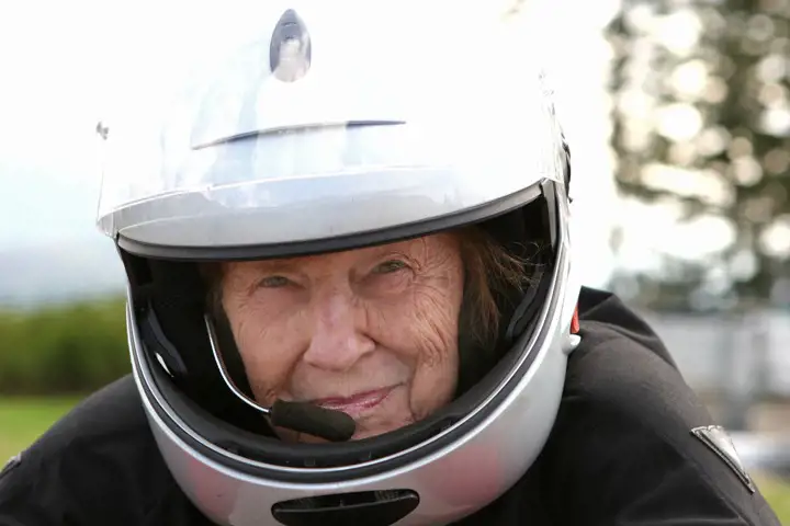 Äldre kvinna med motorcykelhjälm