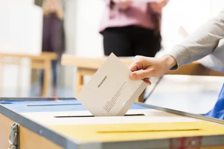 Person lägger ner valkuvert i valurna