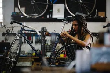 En ung kvinna meckar med en cykel