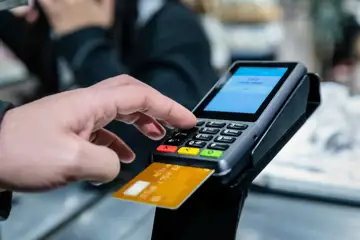 Ett kort betalas med i kortdragare i butik