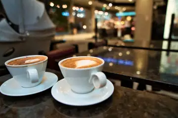 Två lyxiga kaffekoppar på ett kafébord